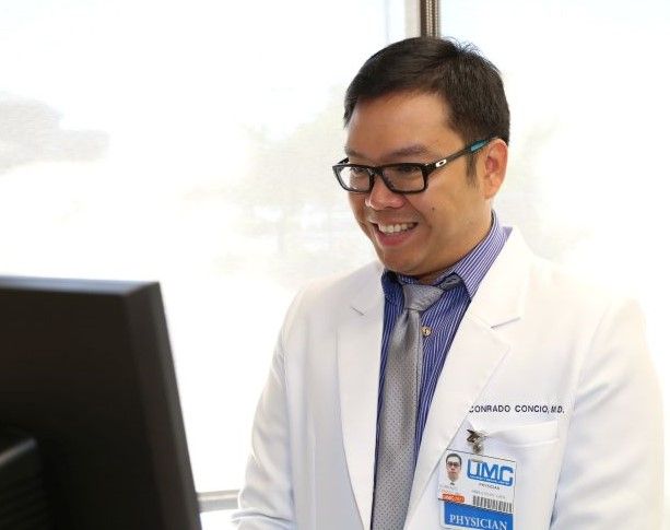 UMC doctor looking at computer smiling